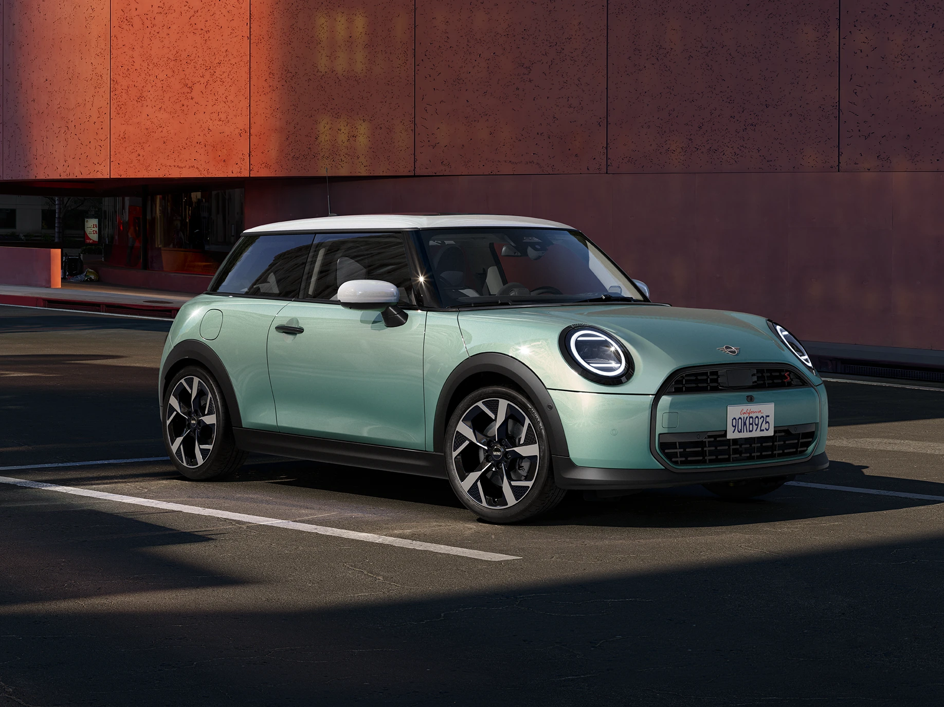 Bočný pohľad spredu na MINI Cooper vo farbe Ocean Wave Green, so strechou White.