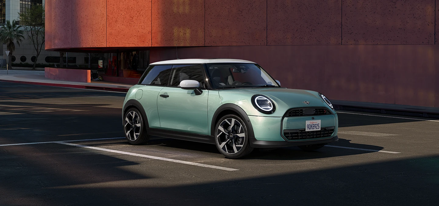 Bočný pohľad spredu na MINI Cooper vo farbe Ocean Wave Green, so strechou White.