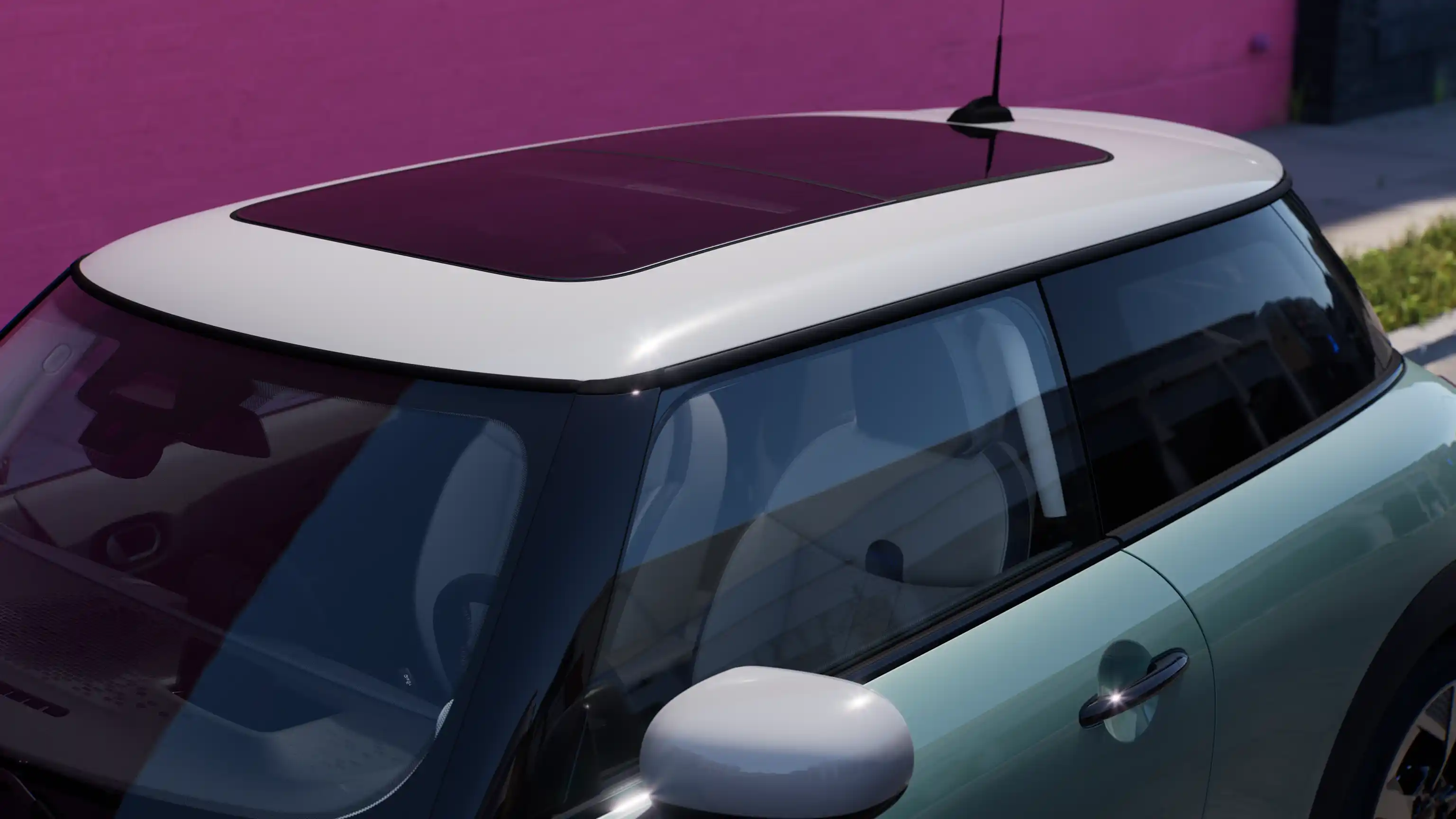 Pohľad zhora na MINI Cooper vo farbe Ocean Wave Green s kontrastnou strechou a veľkým skleneným strešným oknom.