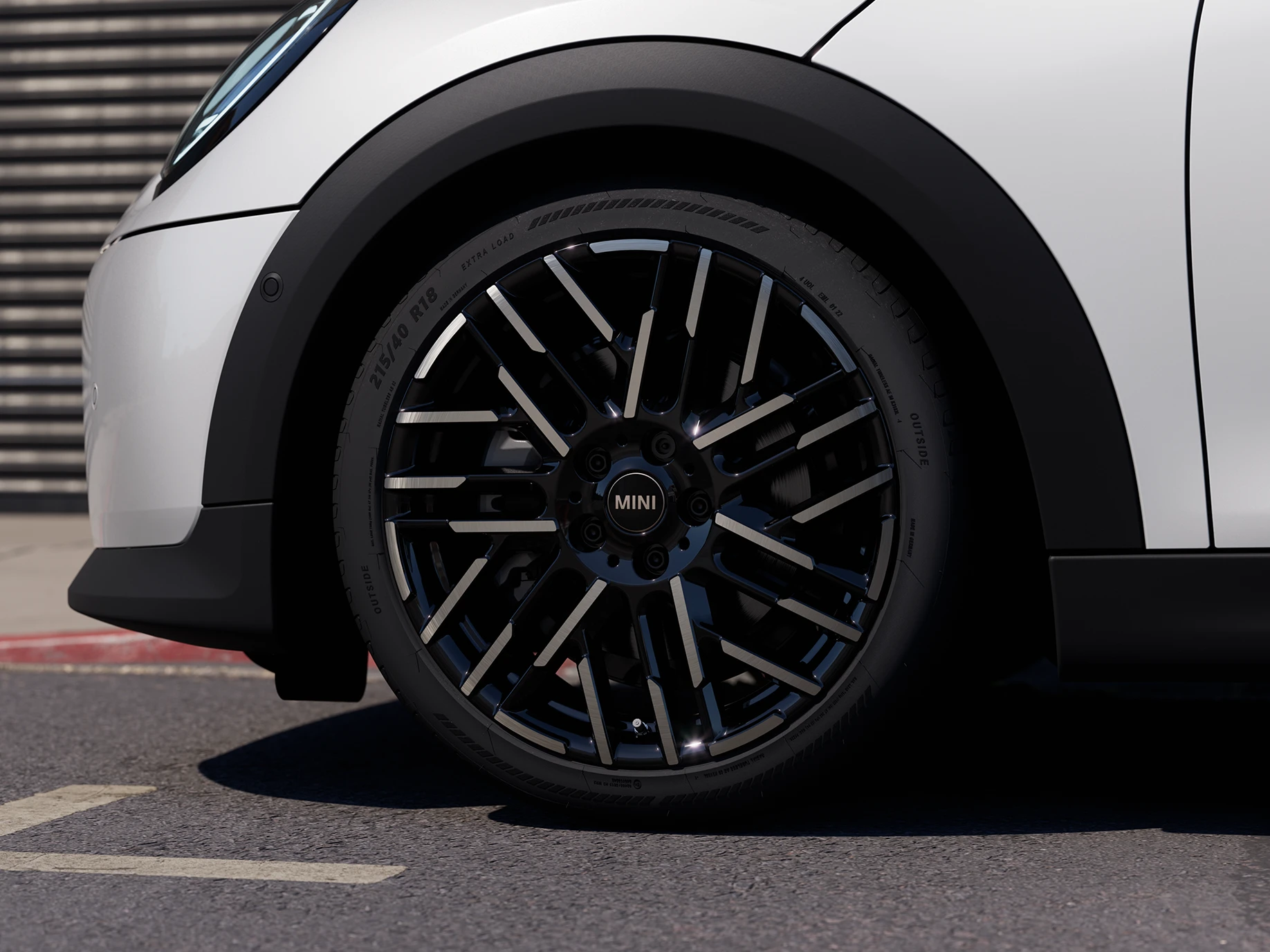 Detailný záber MINI Cooper 5-dverového vo farbe Nanuq White s dvojfarebnými diskami kolies Night Flash Spoke.