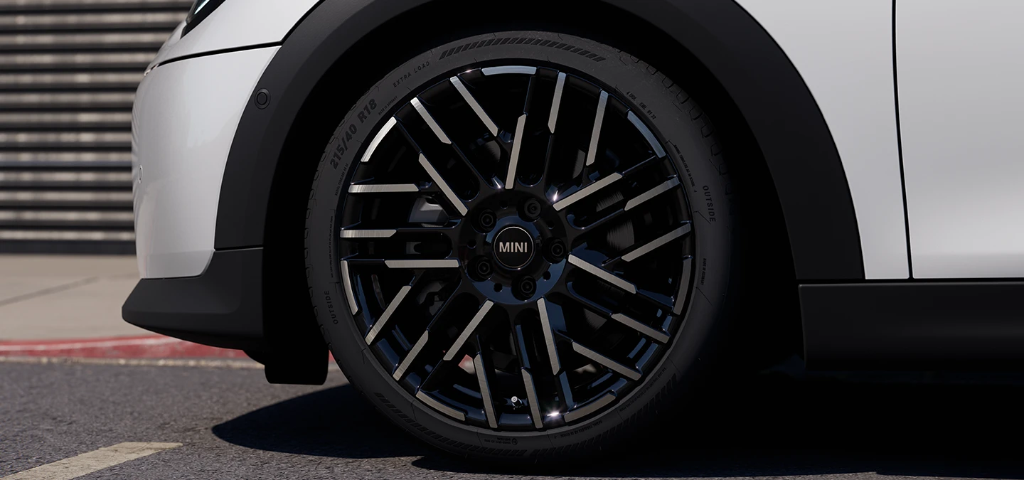 Detailný záber MINI Cooper 5-dverového vo farbe Nanuq White s dvojfarebnými diskami kolies Night Flash Spoke.