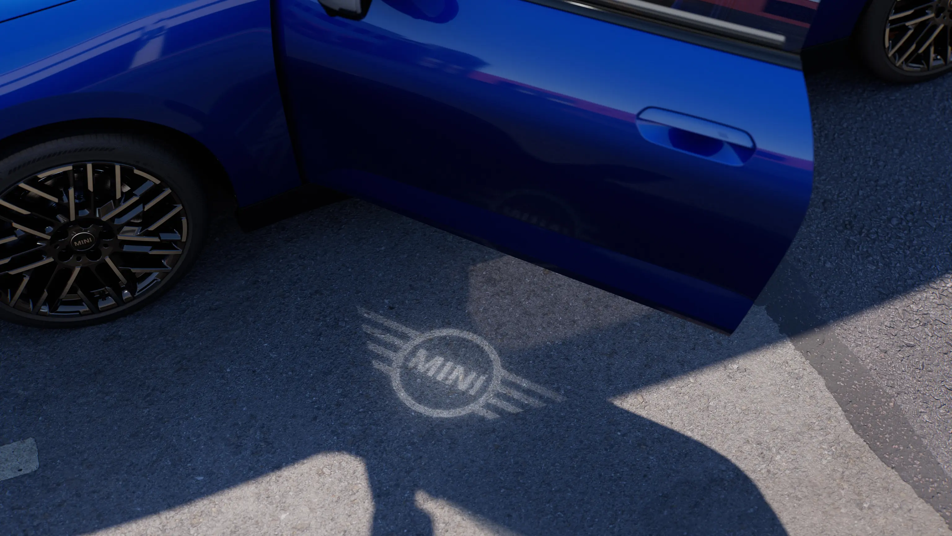 Pohľad na exteriér čisto elektrického MINI Cooper s otvorenými dverami a uvítacím svetlom s logom MINI na zemi