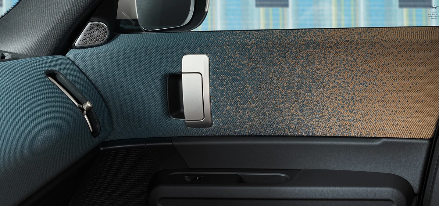 Pohľad zblízka na interiérový dizajn čisto elektrického MINI Countryman so zameraním na dvere a palubnú dosku.