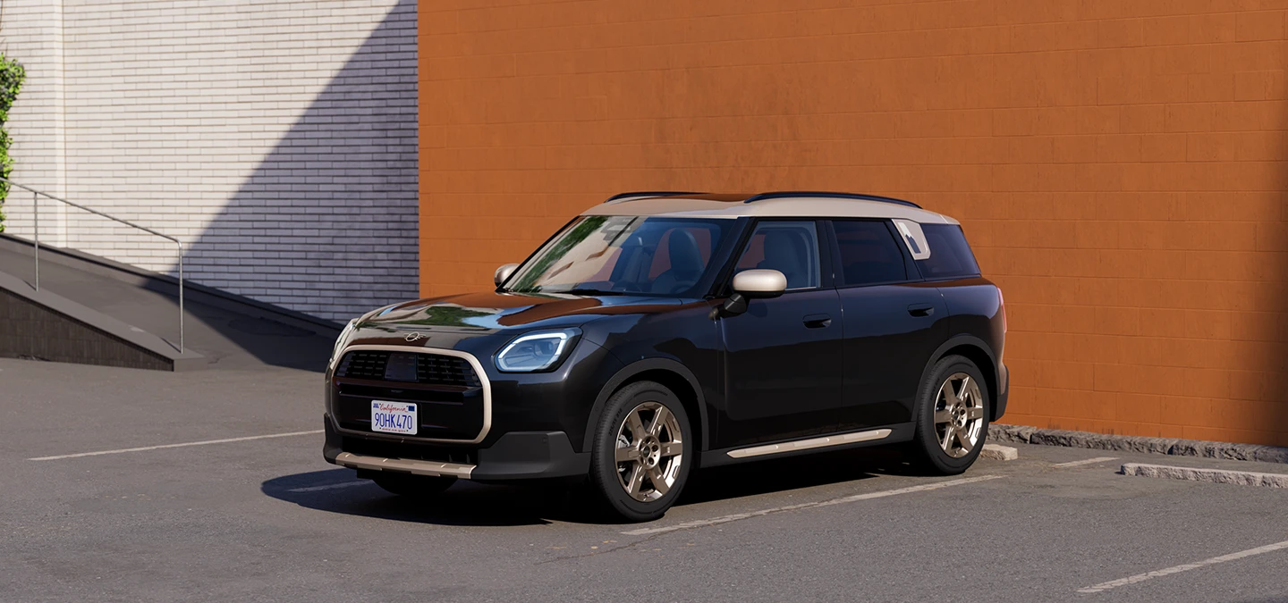 Pohľad z prednej strany na MINI Countryman vo farbe Midnight Black so strechou Vibrant Silver, na parkovisku.