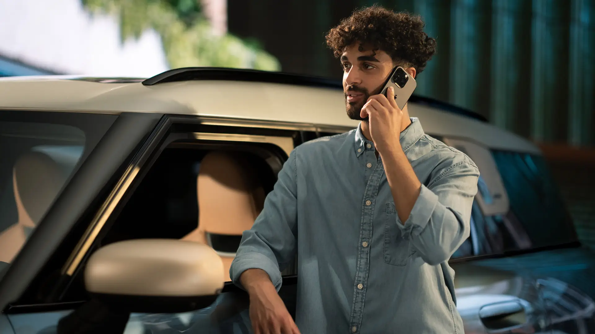 MINI Proactive Care – muž stojí vedľa svojho MINI a telefonuje s konzultantom servisného strediska.