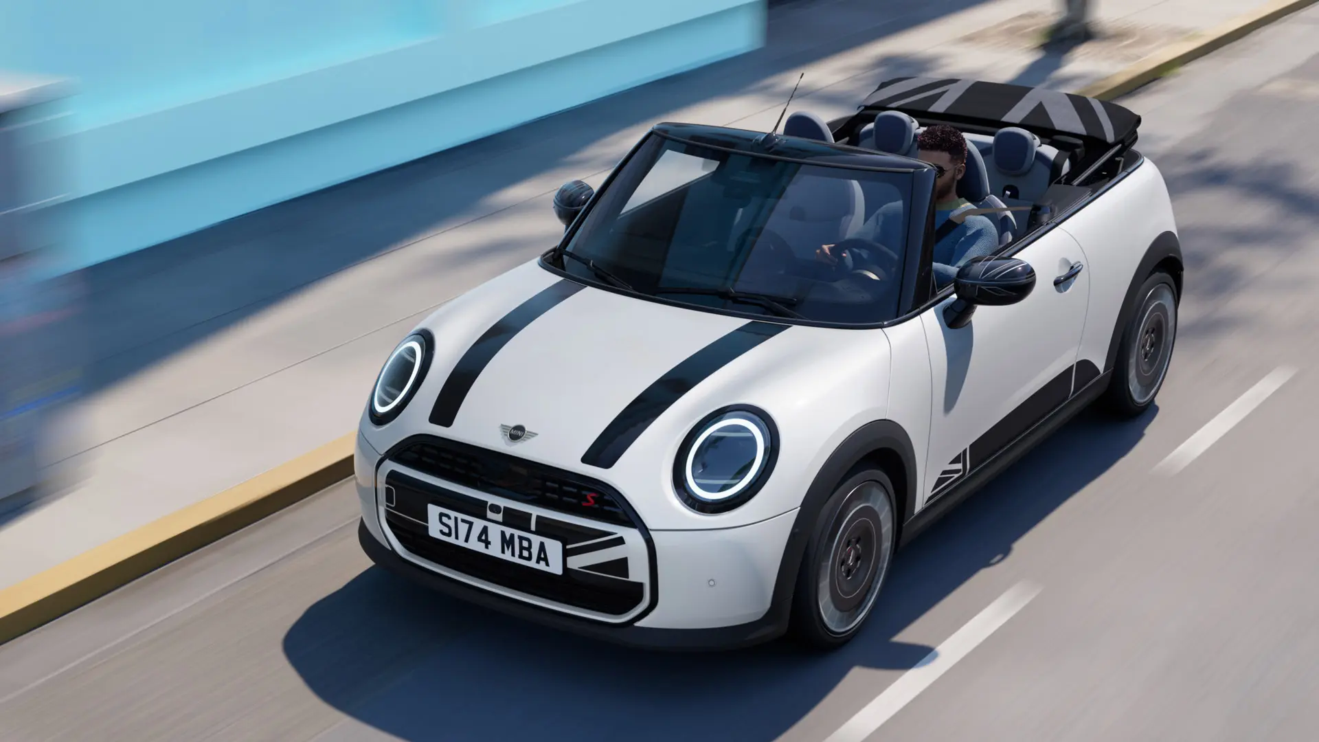 Horný pohľad na MINI Cabrio vo farbe Nanuq White s fóliami na kapotu MINI Heritage v čiernej farbe. 