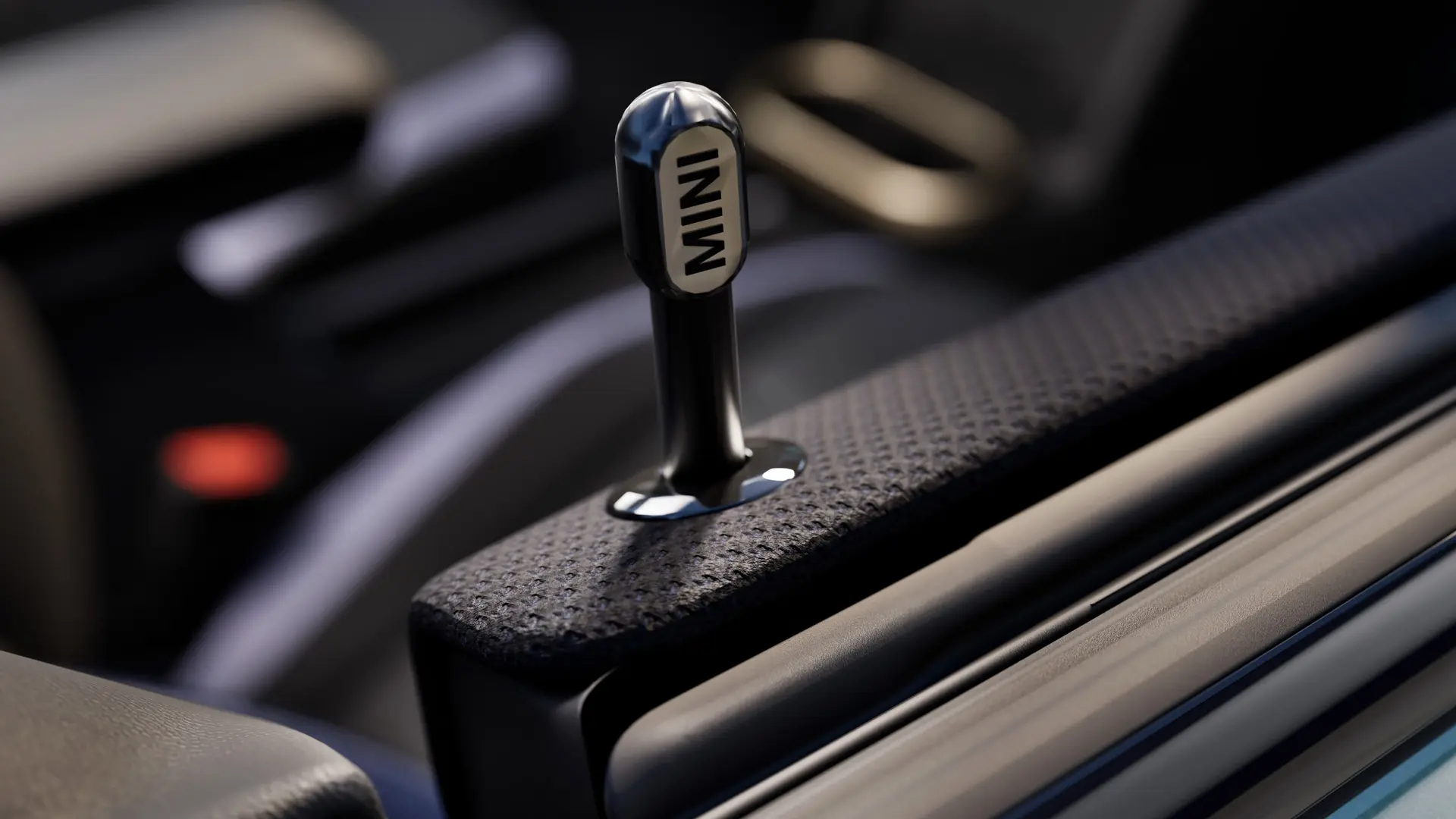 Detailný pohľad na originálny MINI interiérový zamykací kolík dverí z čierneho eloxovaného hliníka.