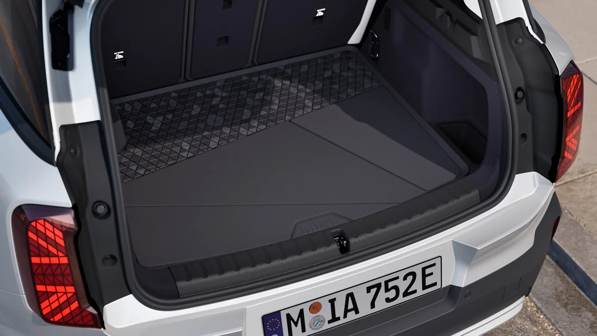 Čierna rozmerovo presná MINI rohož do batožinového priestoru s vyvýšeným okrajom na všetkých stranách na ochranu pred znečistením a vlhkosťou.