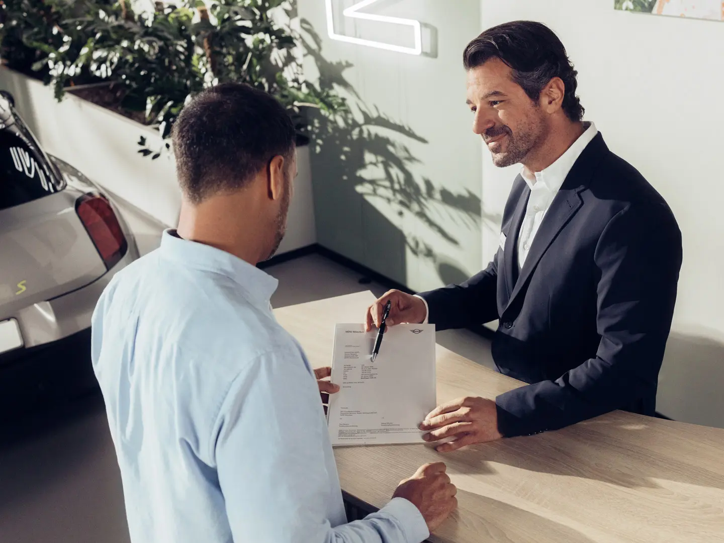 Servisný asistent partnera MINI informuje zákazníka o možnostiach služby poistenia pneumatík MINI.