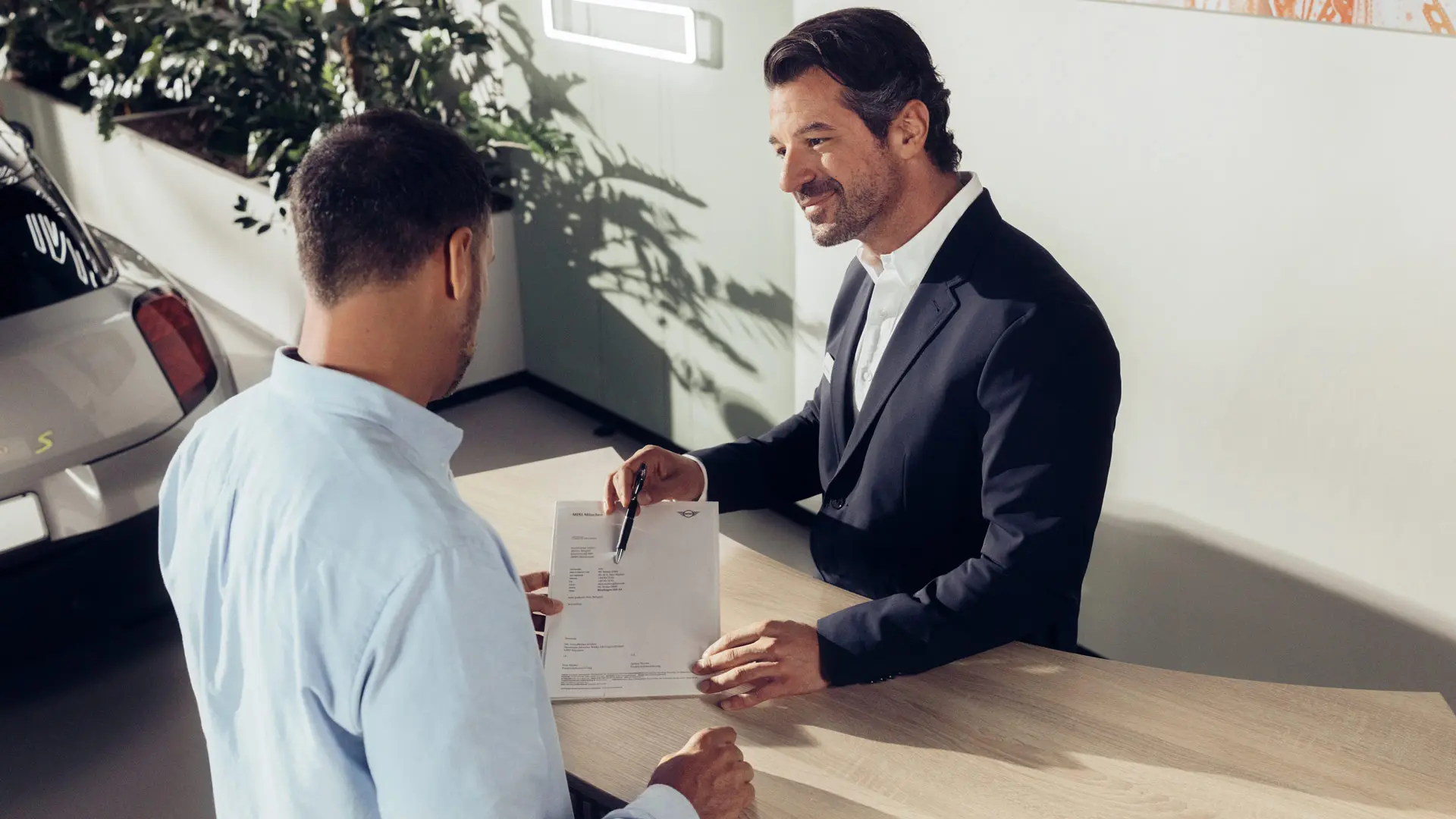 Servisný asistent partnera MINI informuje zákazníka o možnostiach služby poistenia pneumatík MINI.