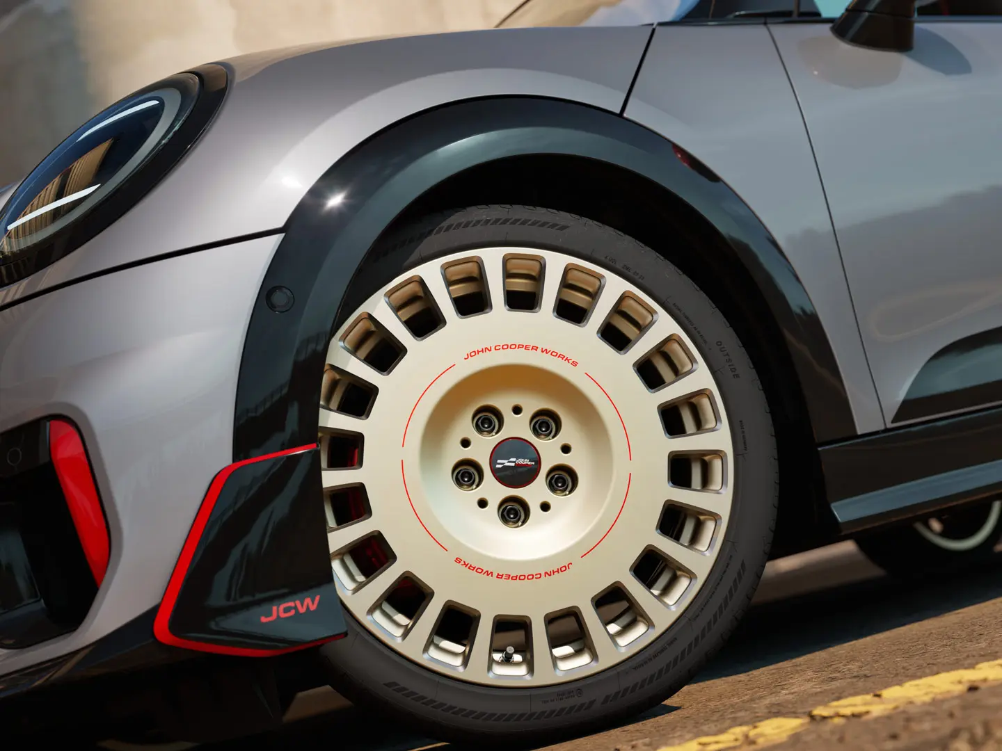 Detailný záber 18-palcového kolesa JCW Rallye Spoke 964 vo dvojfarebnom vyhotovení Vibrant Silver/diamantové frézovanie a predné krídlo.