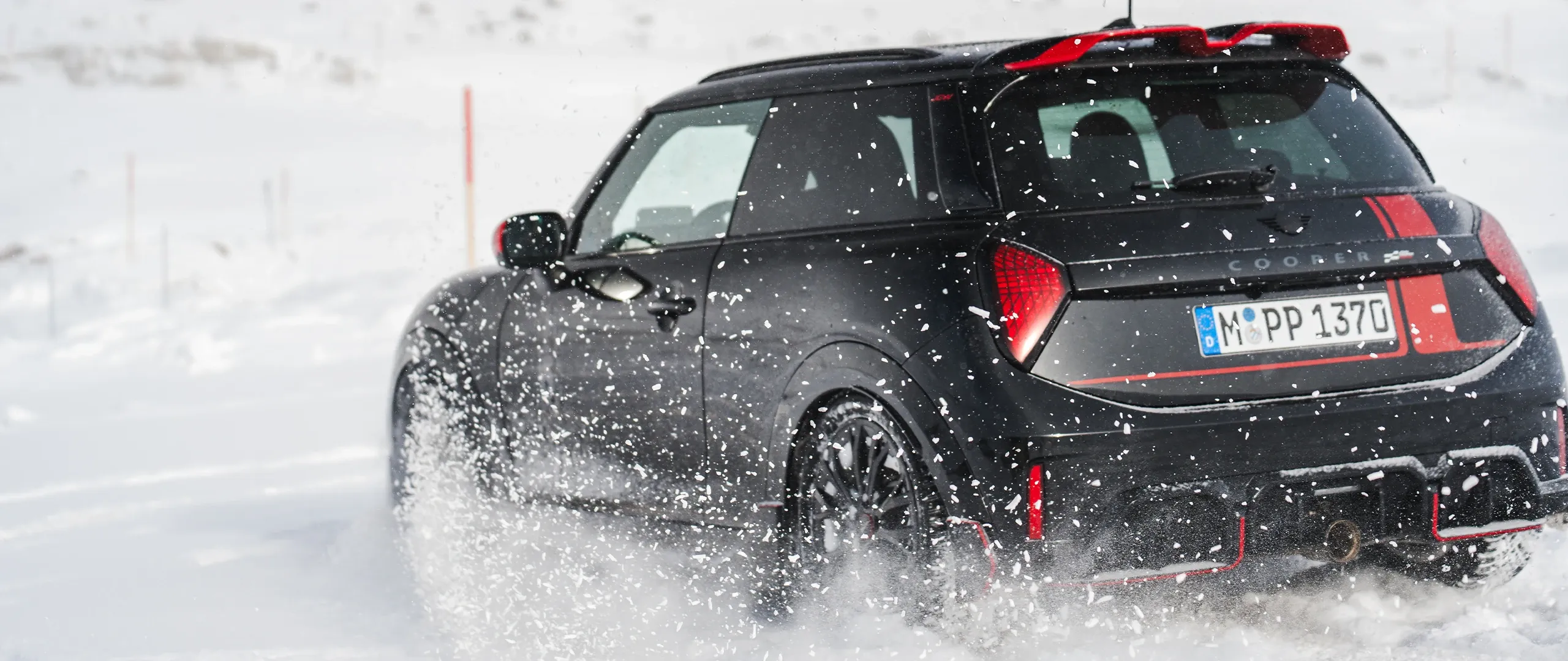 Zadný pohľad na MINI Cooper JCW počas jazdy na snehu.