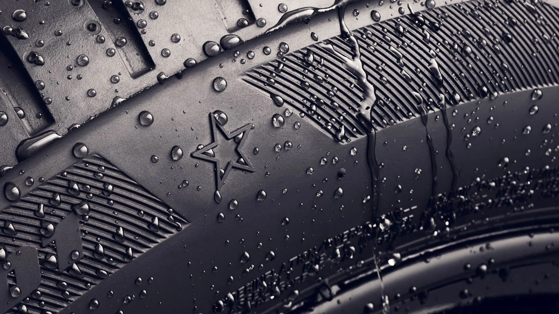 Detailný záber bočnej steny pneumatiky so zobrazením symbolu hviezdičky, čo znamená, že pneumatika je schválená na dosiahnutie optimálneho výkonu vozidiel MINI. 