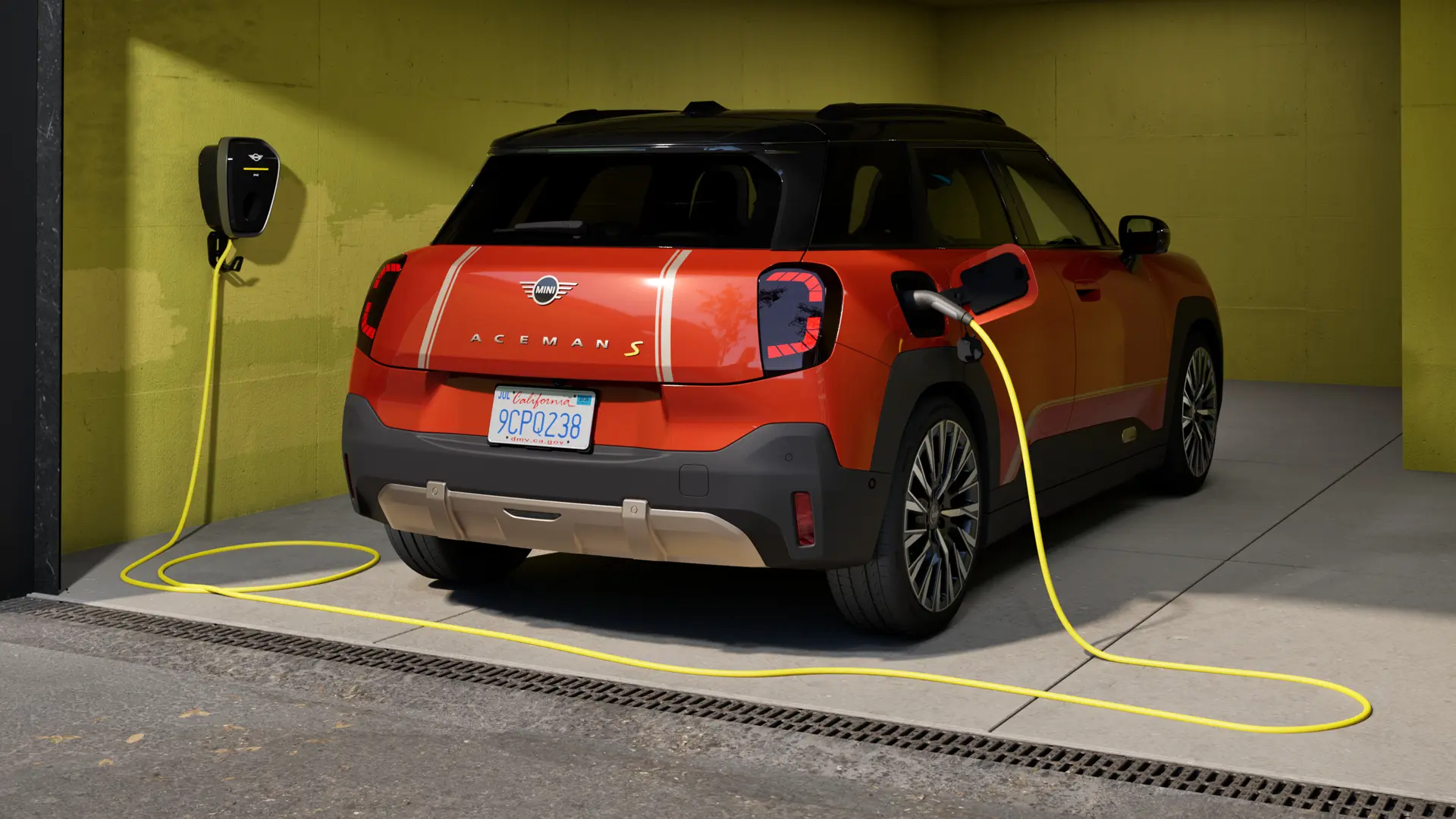 Čisto elektrické MINI Aceman S počas nabíjania zariadením MINI Wallbox Plus, zadný pohľad, v garáži.