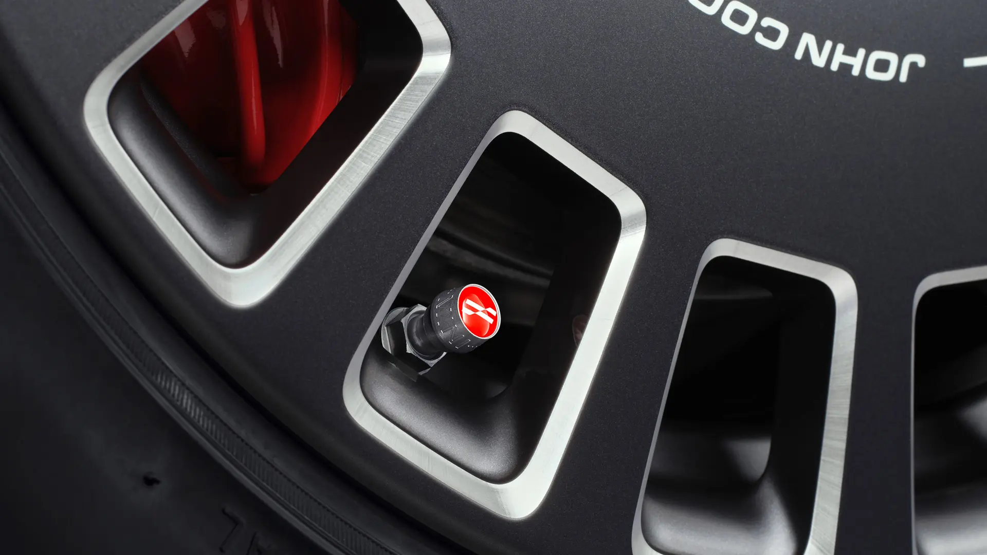 Hliníkové čiapočky ventilov John Cooper Works pre štýlový červený vizuálny akcent na pneumatike. 