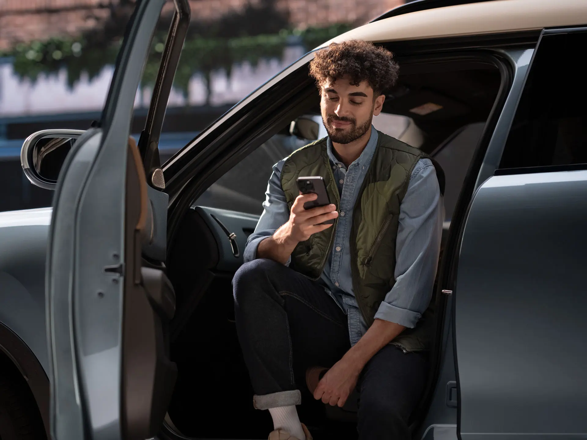 Muž, ktorý si rezervuje servisný termín pomocou svojho mobilného telefónu.