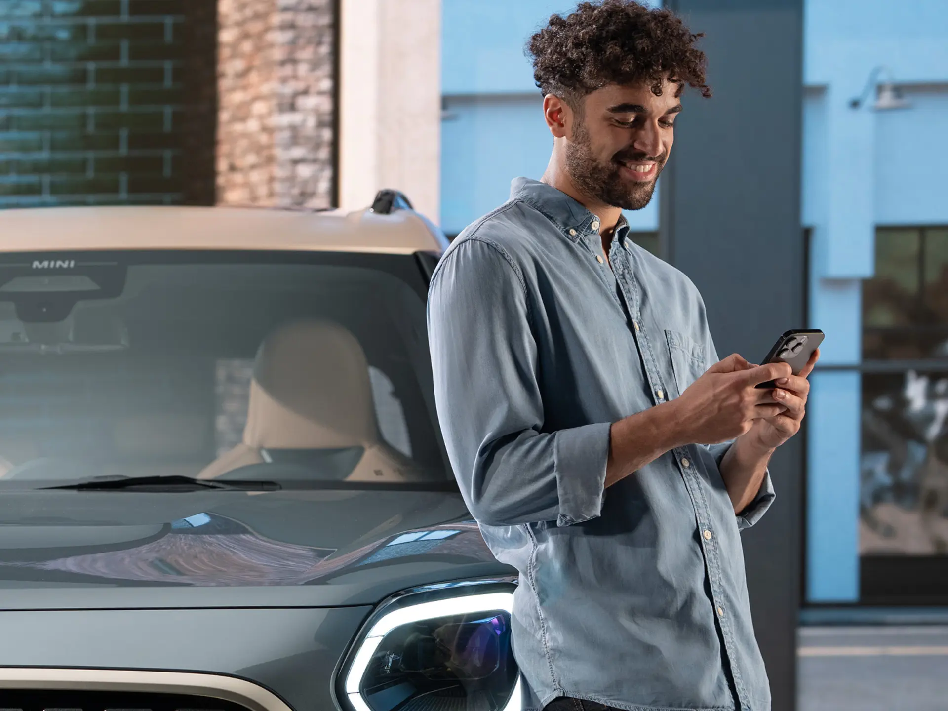 MINI personalizovácia servisných termínov - muž, ktorý píše do telefónu vedľa MINI