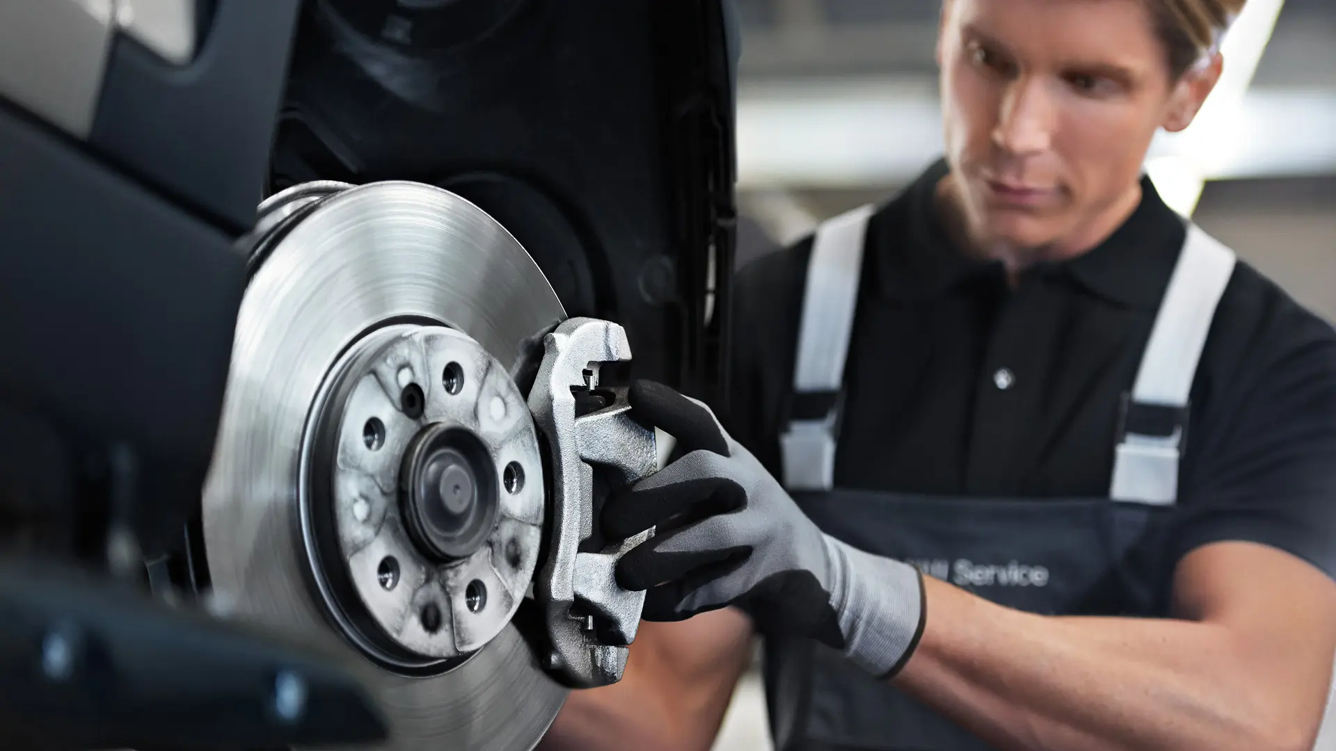 Pracovník MINI kontrolujúci brzdy