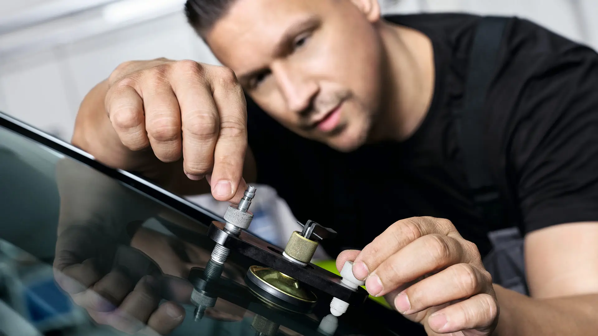 MINI zamestnanec opravuje čelné sklo.